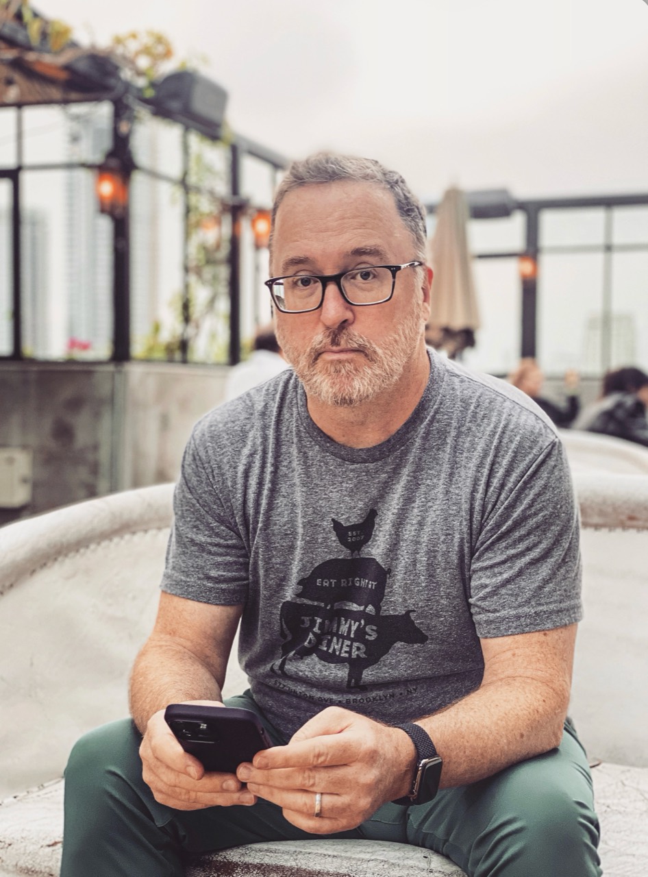 Portrait of Tom Budd seated in a bright café